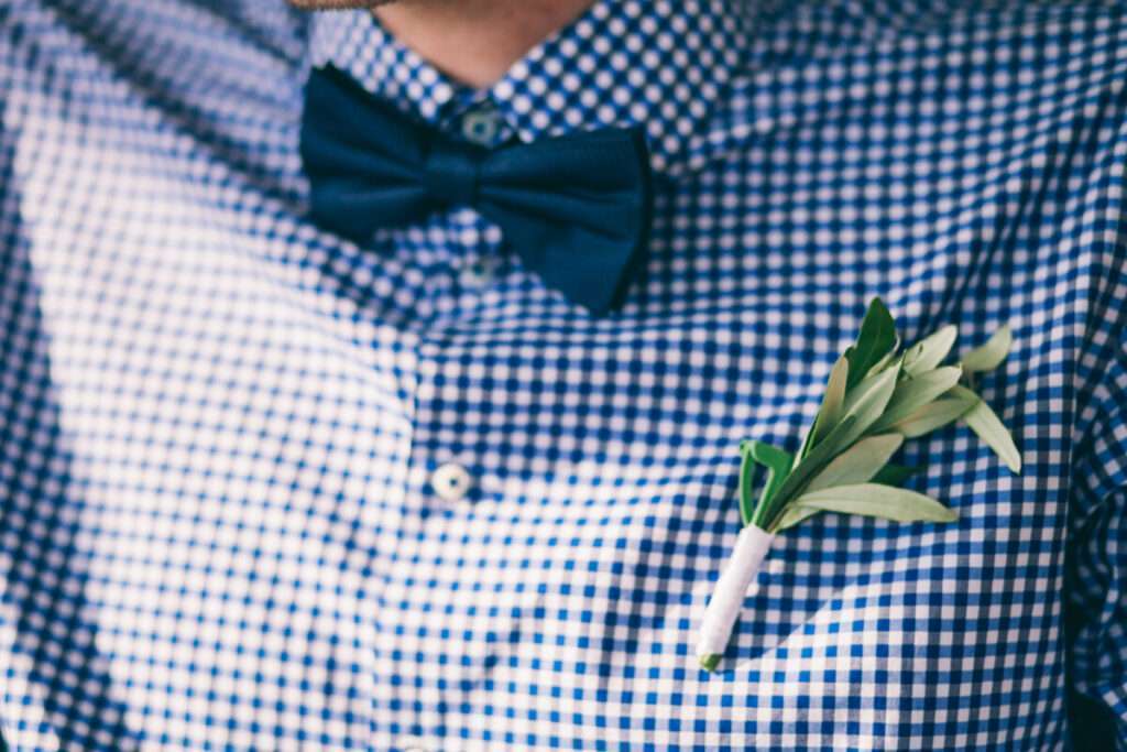 Look du marié avec chemise à carreaux blanc et bleu et noeud papillon marine