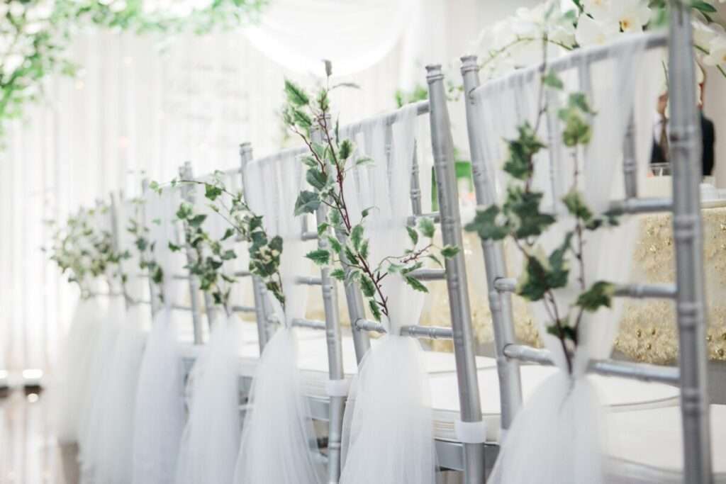 Décoration de cérémonie mariage: chaises argentées sublimées par du tulle orné de lierre